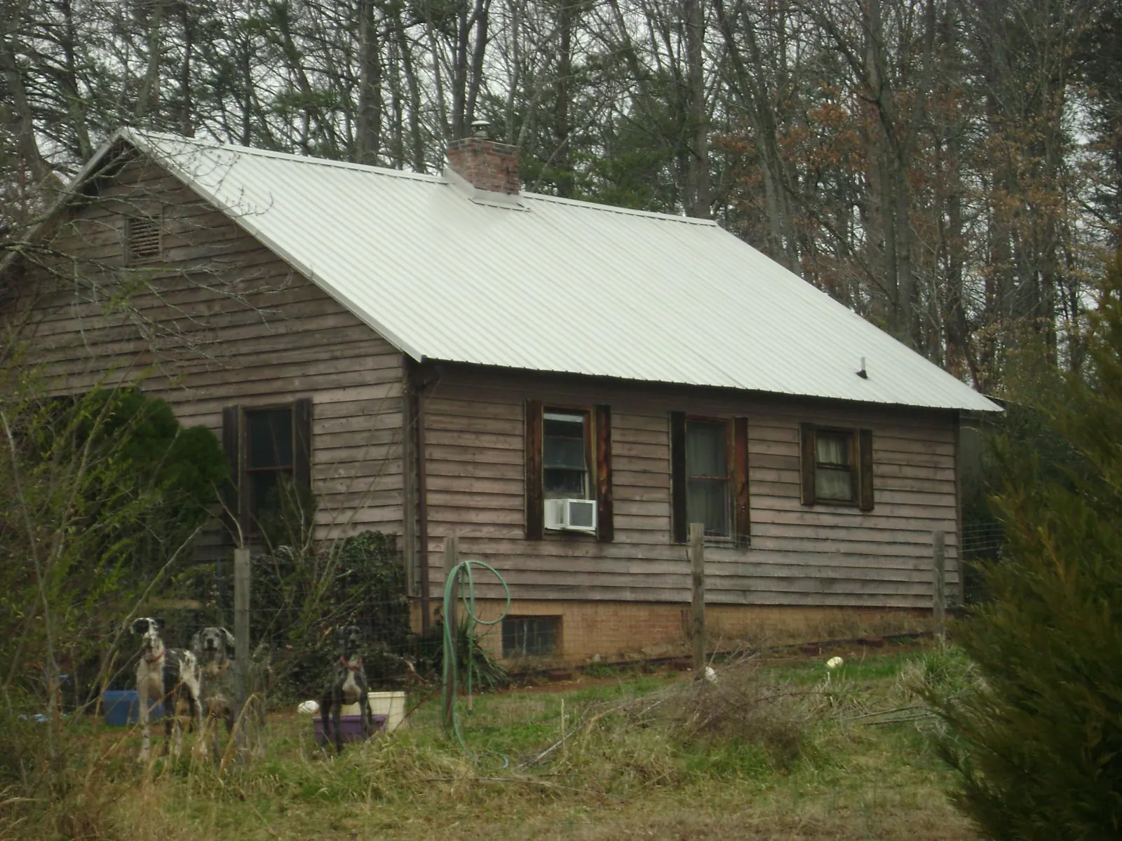 White metal roof on an old wood sided farmhouse, from a Metal Roof Installation job in Fairfax Station
